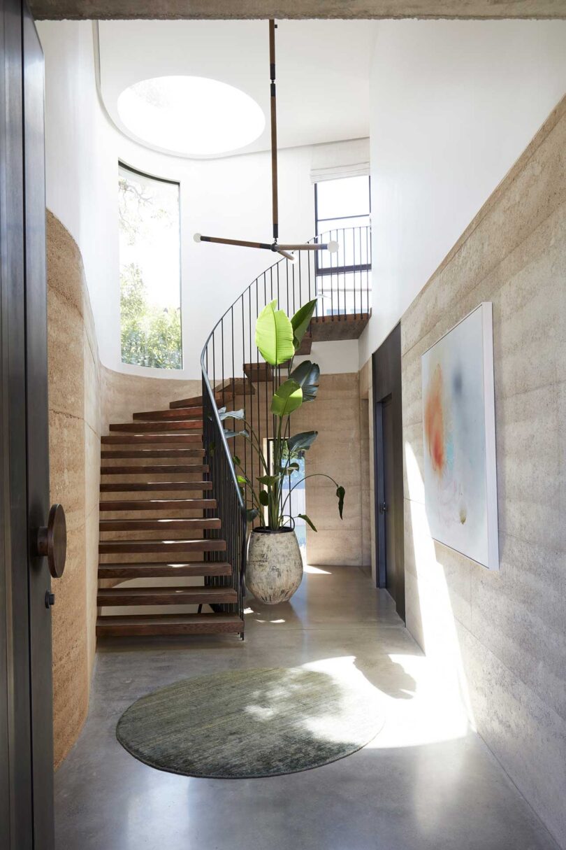 interior entry shot of curved staircase with skylight above