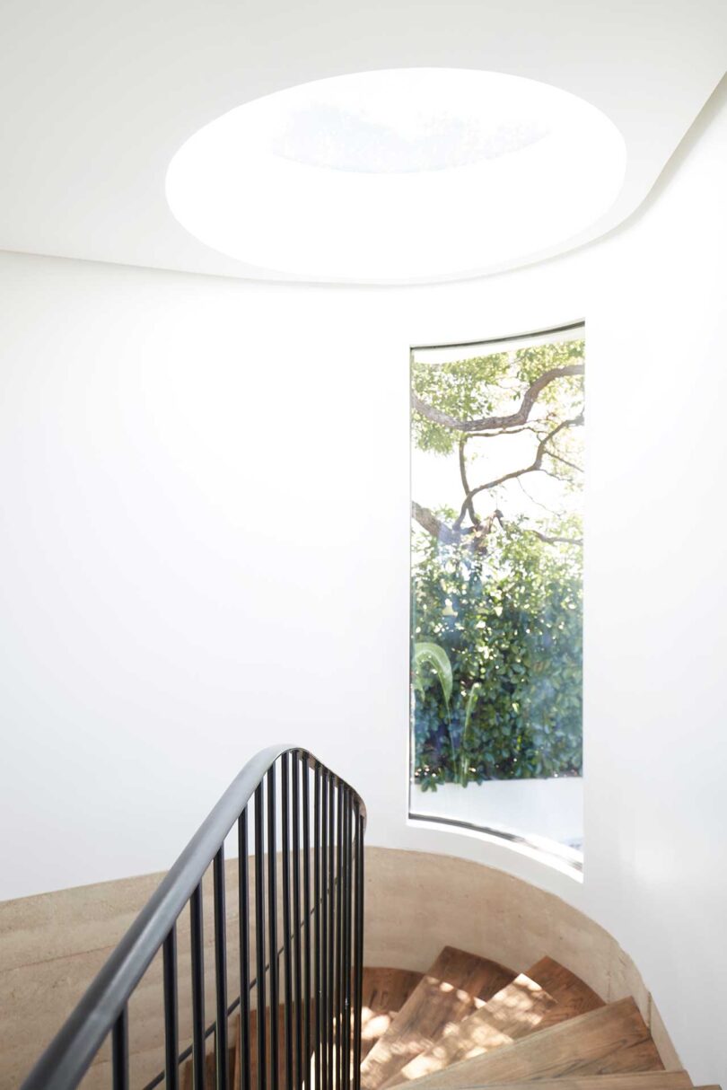 interior shot of curved staircase with skylight above