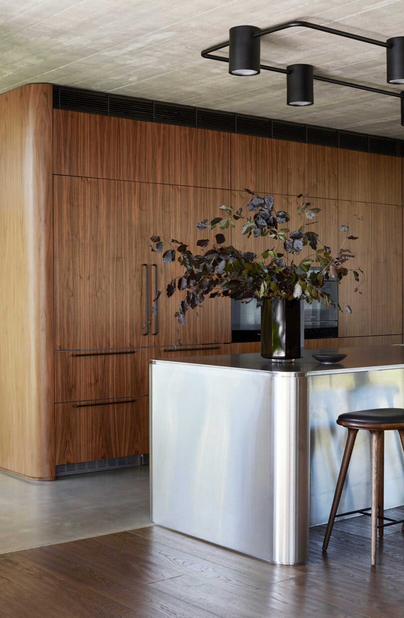 angled interior view of modern kitchen with wood and stainless cabinets