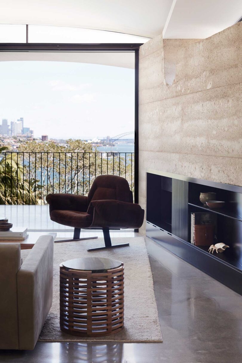 partial view of modern living room with modern chair in front of fireplace