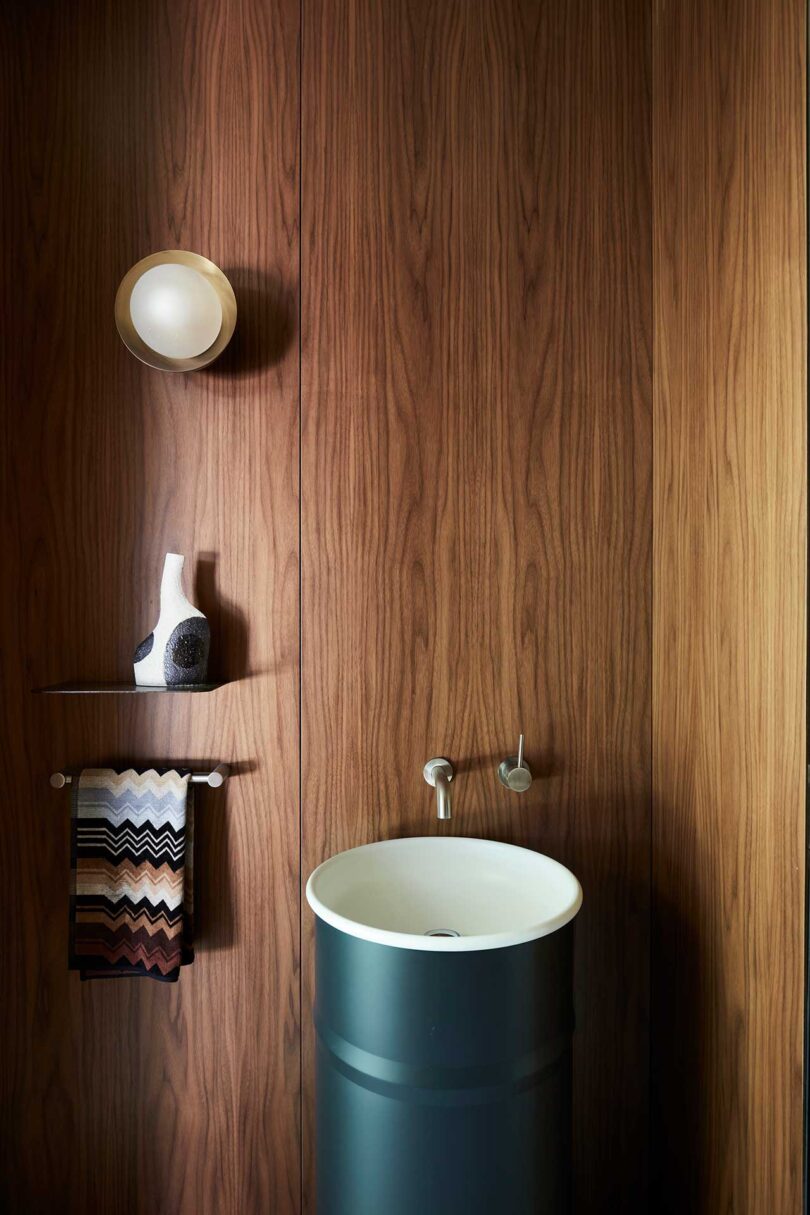 view of wood paneled powder room with round barrel green sink