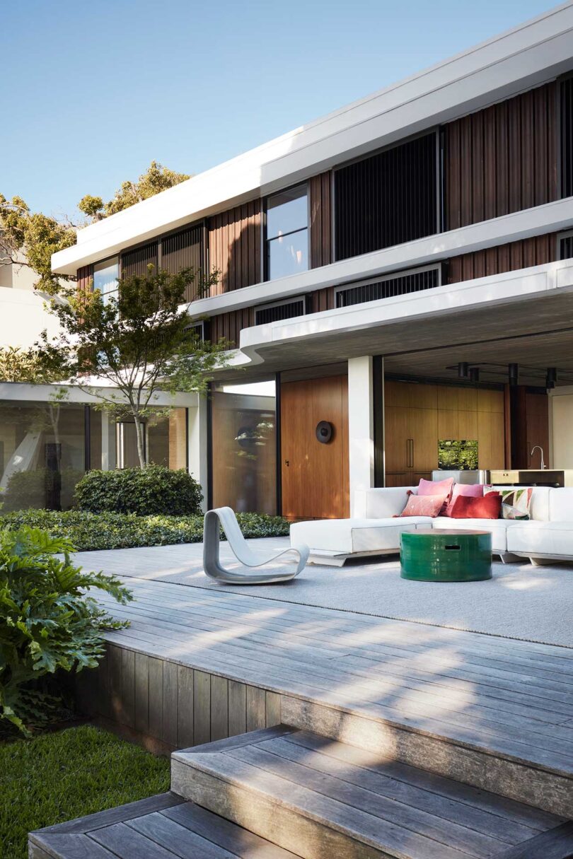 angled exterior view of white house with patio with various pieces of furniture