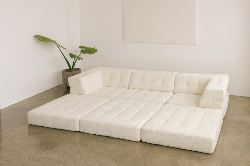 three-seater single layer white sofa with extended cushions in a styled interior space