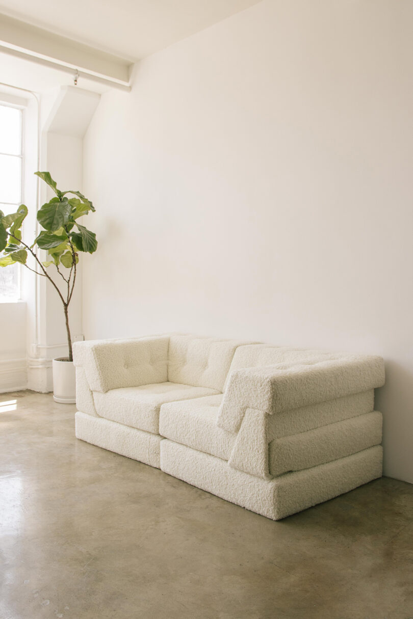 two-seater double layer white sofa in a styled interior space