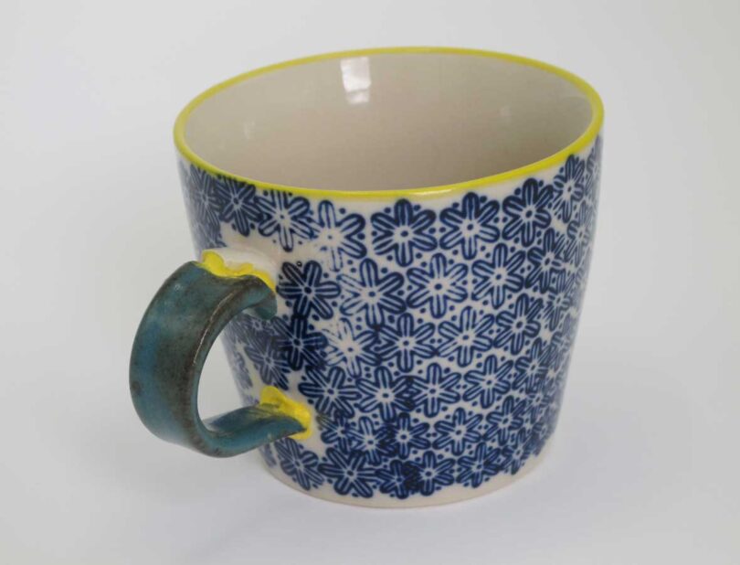 closeup of broken blue and yellow mug repaired