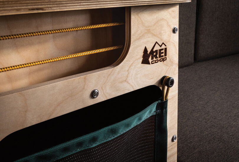 Detail of yellow bungie cords and wood cabinetry stamped with REI Co-op logo.