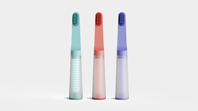 Three one&done toothbrushes in lagoon, coral, and blueberry coloras standing vertically on its base end, each with a clear tube with 20 toothpaste tablets stored within.