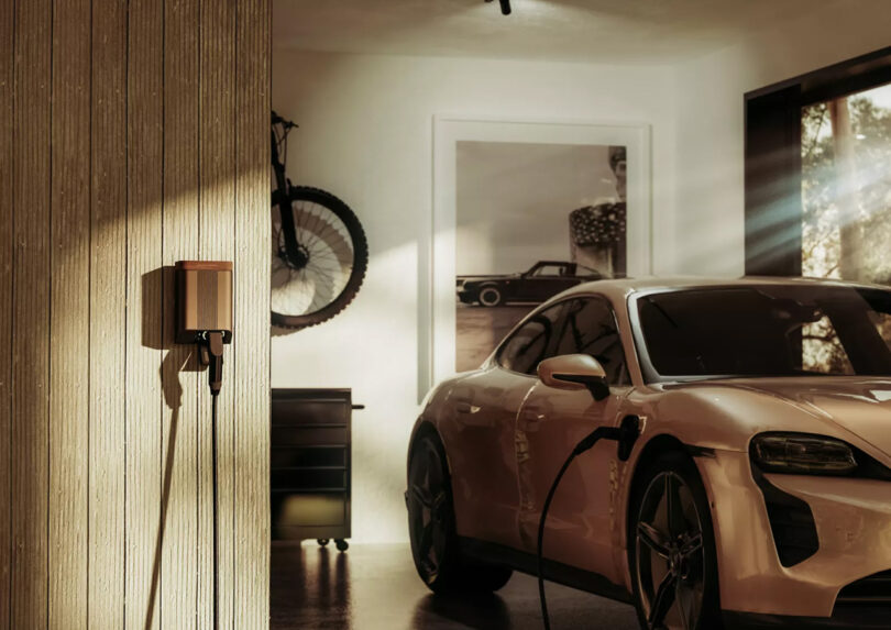 Simpson & Partners EV charging system installed indoors in a garage, plugged in and charging a bronze hued Porsche sports car.