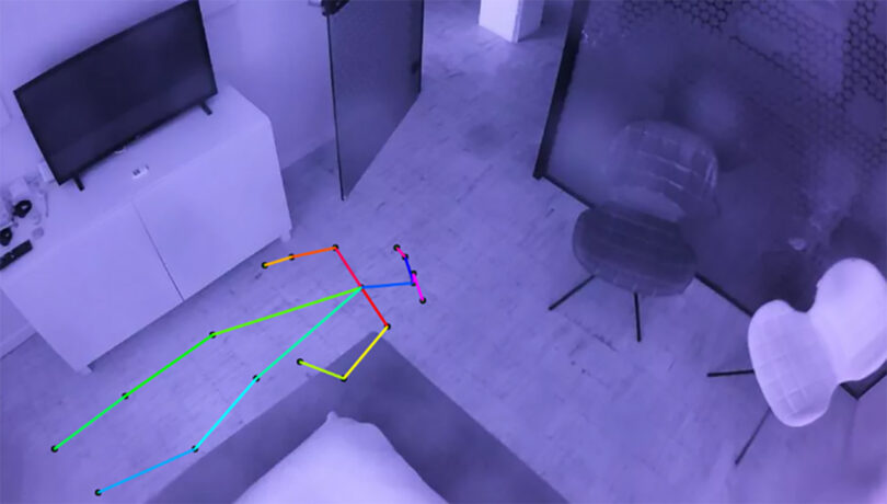 A multi-color stick figure set prone on the floor of a living space at night, as recorded by Nobi's overhead light's camera.