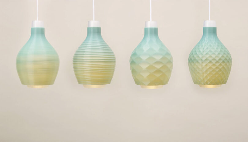 All four of the Coastal Breeze collection pendant lamps shown illuminated, glowing with a gradient transitioning from light green-yellow at the bottom into an aqua green hue at the top. Each lamp is textured to evoke sand dunes and the ripple of water.