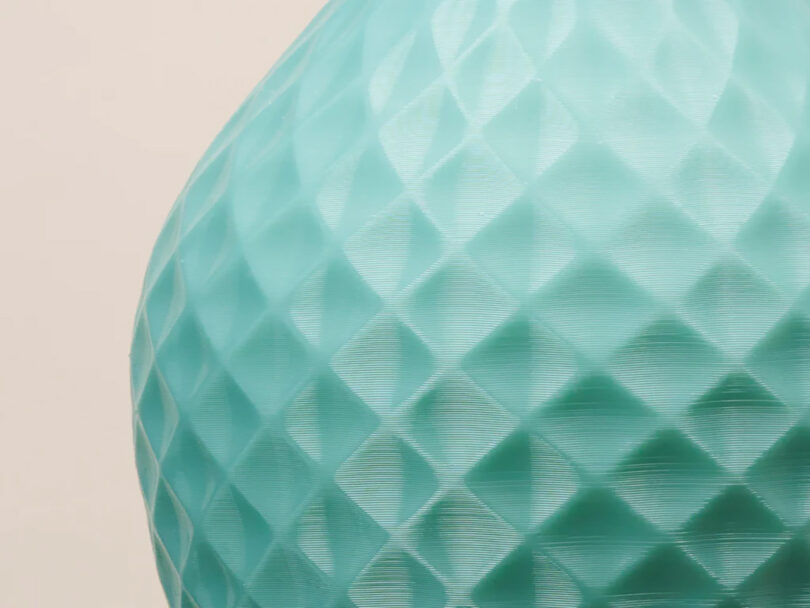 Close up of the small irregularities visible across the green textured design of pendant light created using the additive 3D-printing process.