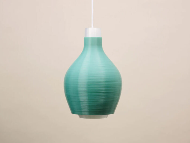 Underside view of the Droplet Three Pendant light designed by Aleksandra Gaca and made using 3D printing technology. Green lamp against light tan background.