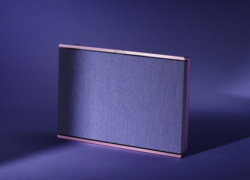 Fall 2023 Atelier Editions Beosound Level wireless speaker in Lilac Twilight color staged against a purple floor and background with shadows cast across it.