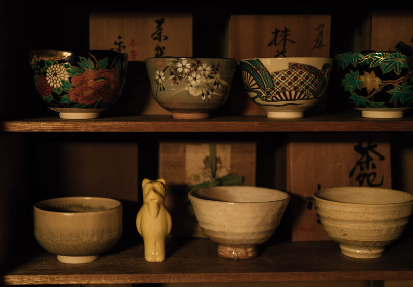 Detail of shelf filled with numerous Japanese ceramic bowls and small DIDO ceramic sculpture designed by MAKHNO Studios.