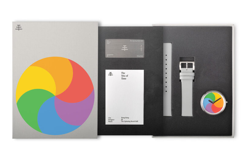 Packaging for The Trio of Time - The Spinning Beach Ball wristwatch, with large color pinwheel cover design, a small user booklet, metal sheet card with unit number, and another padded layer with watch and wrist band inset in foam.