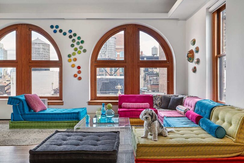 interior view of large open living room with arched windows and colorful low seating