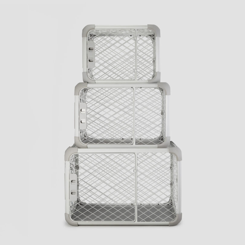 three dog crate/playpens in different sizes stacked on top of one another