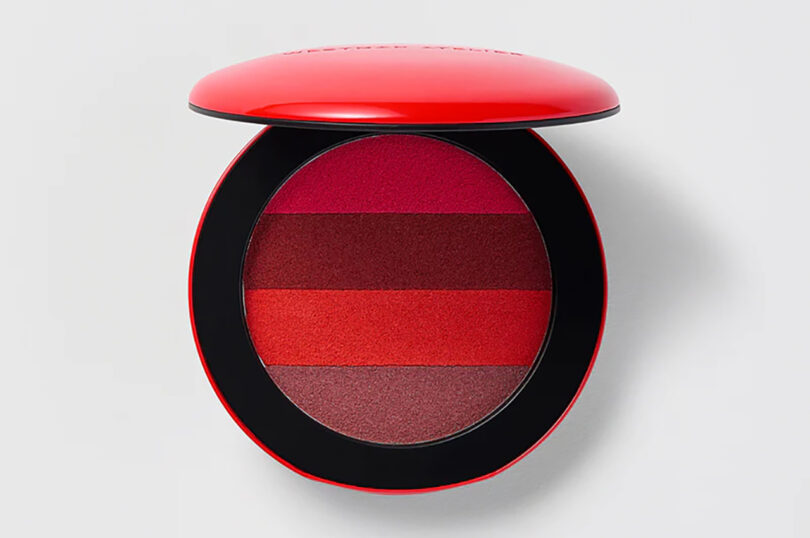 round makeup compact with four shades of red-toned lipstick colors