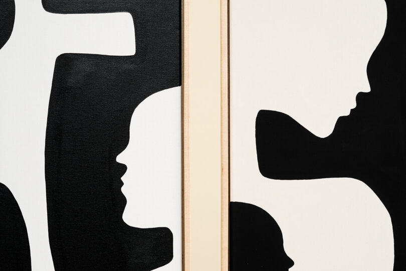 detail of two black and white abstract paintings hanging on a wall