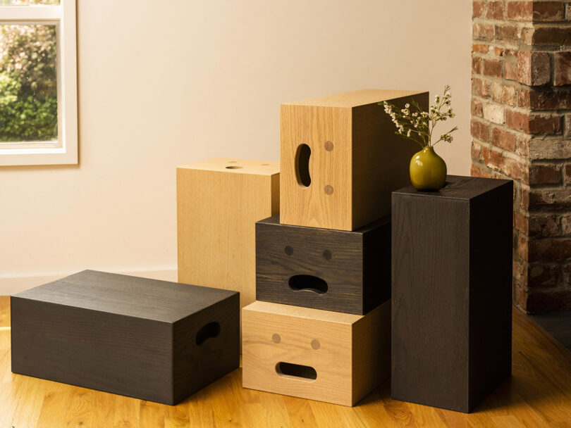 six dark and light wood boxes fashioned after apple crates with a smiley face on each side