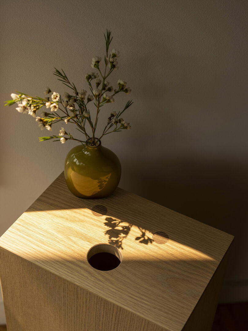 light wood box fashioned after an apple crate with a smiley face on each side being used as a side table