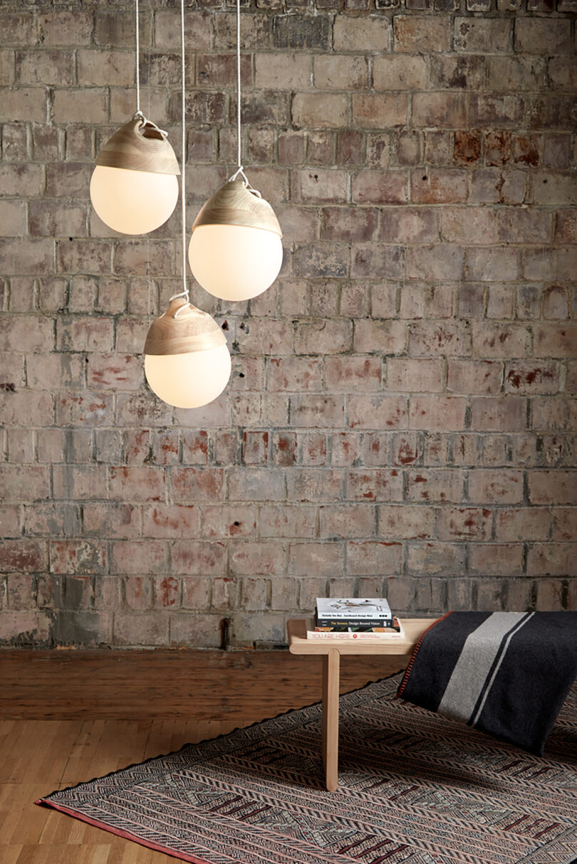 three grouped bulbous cement pendant light hang over a styled interior space