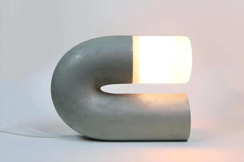 U-shaped grey table lamp that sits on its side