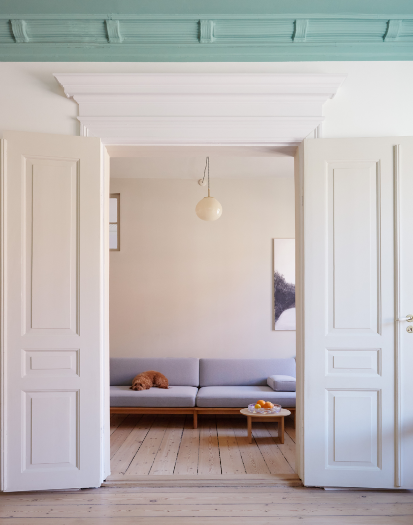 The view through white double doors – the spoke sofa can just be seen on the far wall
