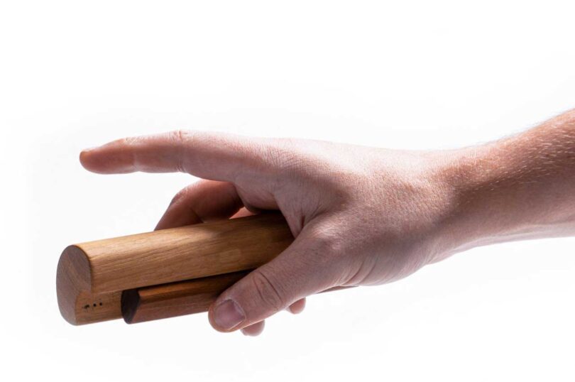 closeup of hand holding two-tone wood shaker