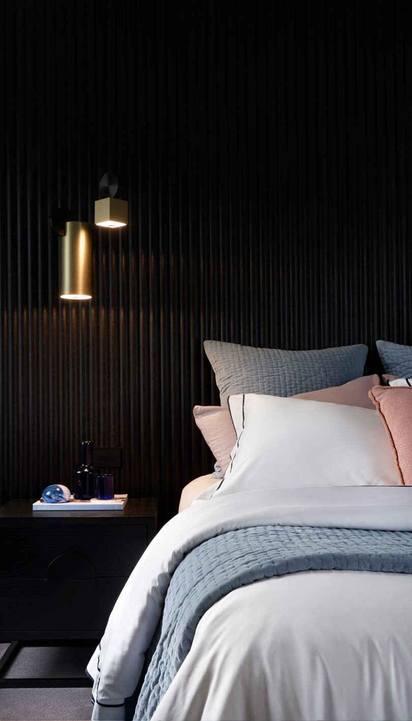 partial view of modern bedroom with dark moody walls and soft bedding