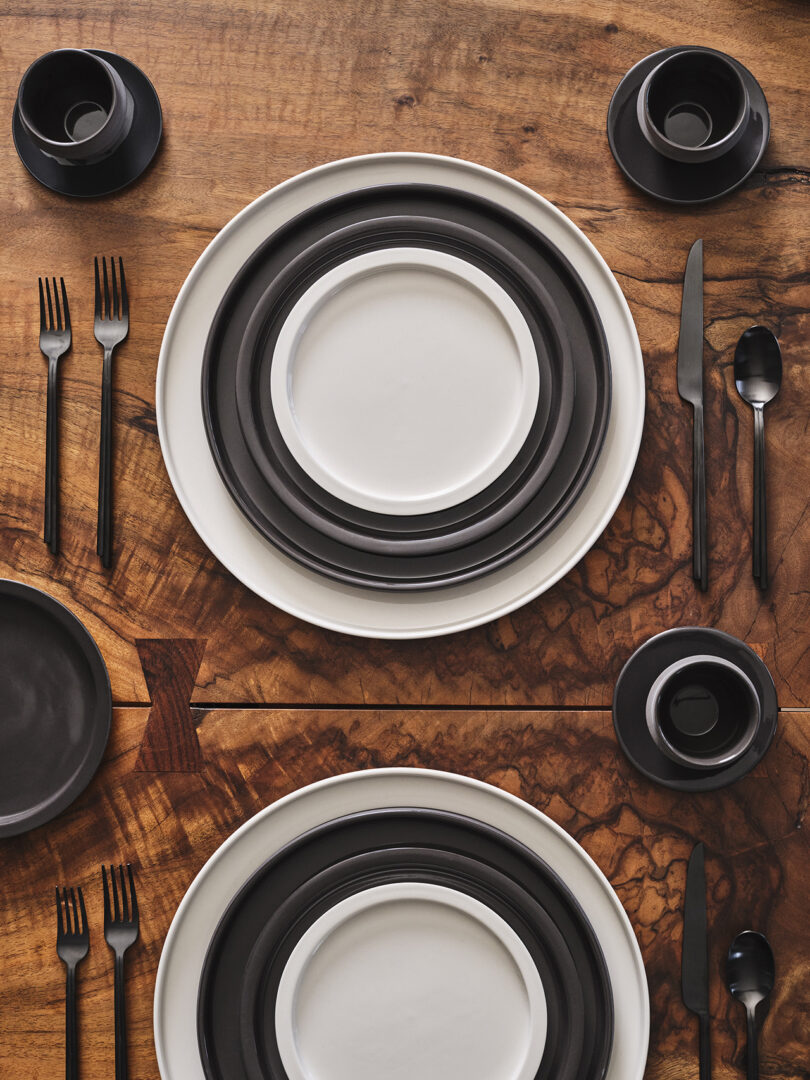 stacked white and black tableware in a styled setting