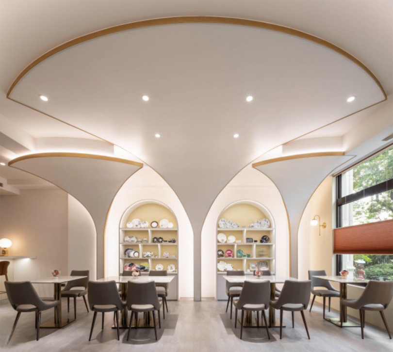 light-filled commercial interior space with architectural arches and tables with chairs