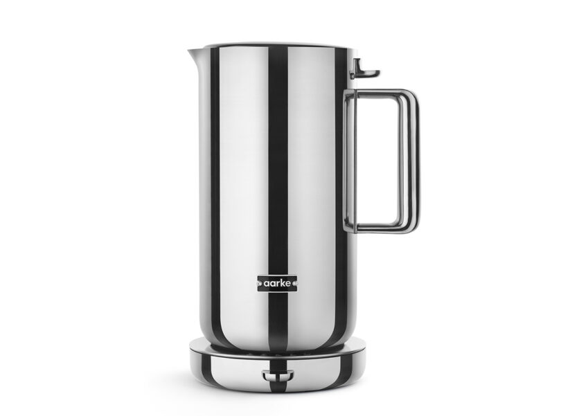 Studio shot of the stainless steel Aarke Kettle with large metal handle and small spout, shown on its rounded base, with small "aarke" logo the only adornment.