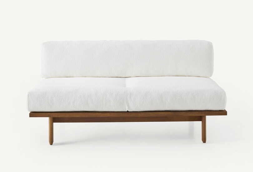 wood framed outdoor loveseat with white upholstery