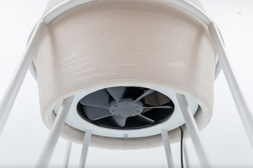 View underneath the Biomimcry 3d printed ceramic cooling vessel revealing the electric fan that helps deliver more air across the vessel's surface area to improve evaporation rates.