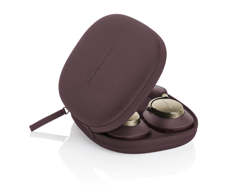 Bowers & Wilkins Px8 in Royal Burgundy Nappa leather finish with gold detailing stored in a matching burgundy carrying case with the lid half open. Bowers & Wilkins logo is branded across the case.