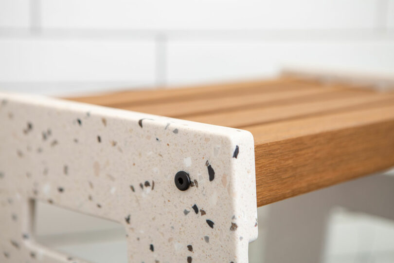 closeup angled view of terrazzo and wood shower seat