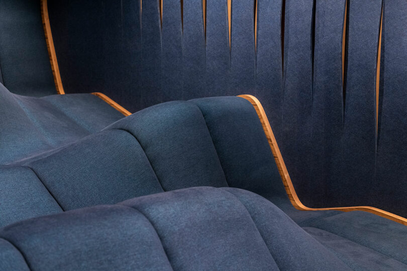 closeup of modern home theater looking out to single undulating dark blue seating block