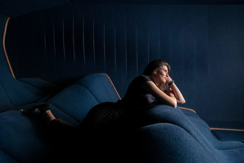 side view of woman laying on stomach propped up on wavy home theater seating