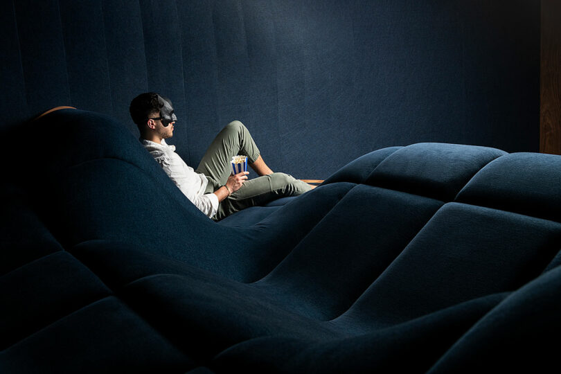 masked man leaning back seating on wavy home theater seating