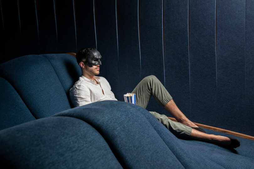 masked man leaning back seating on wavy home theater seating