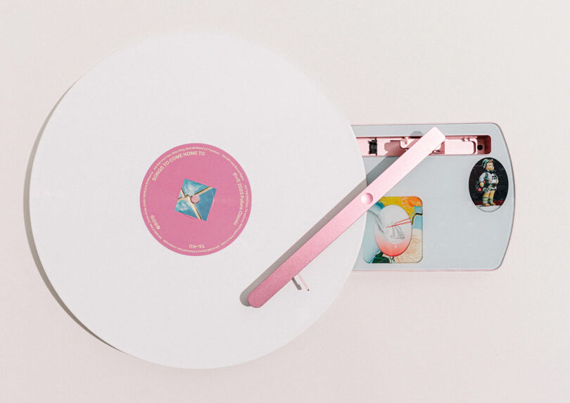 Slim portable COTURN X TA-KU edition in pink turntable with white vinyl album on play.