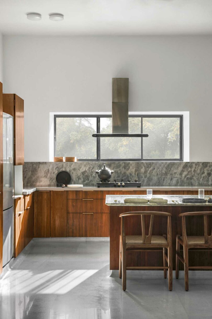 modern kitchen with warm wood cabinets on lower and rich marble backsplash