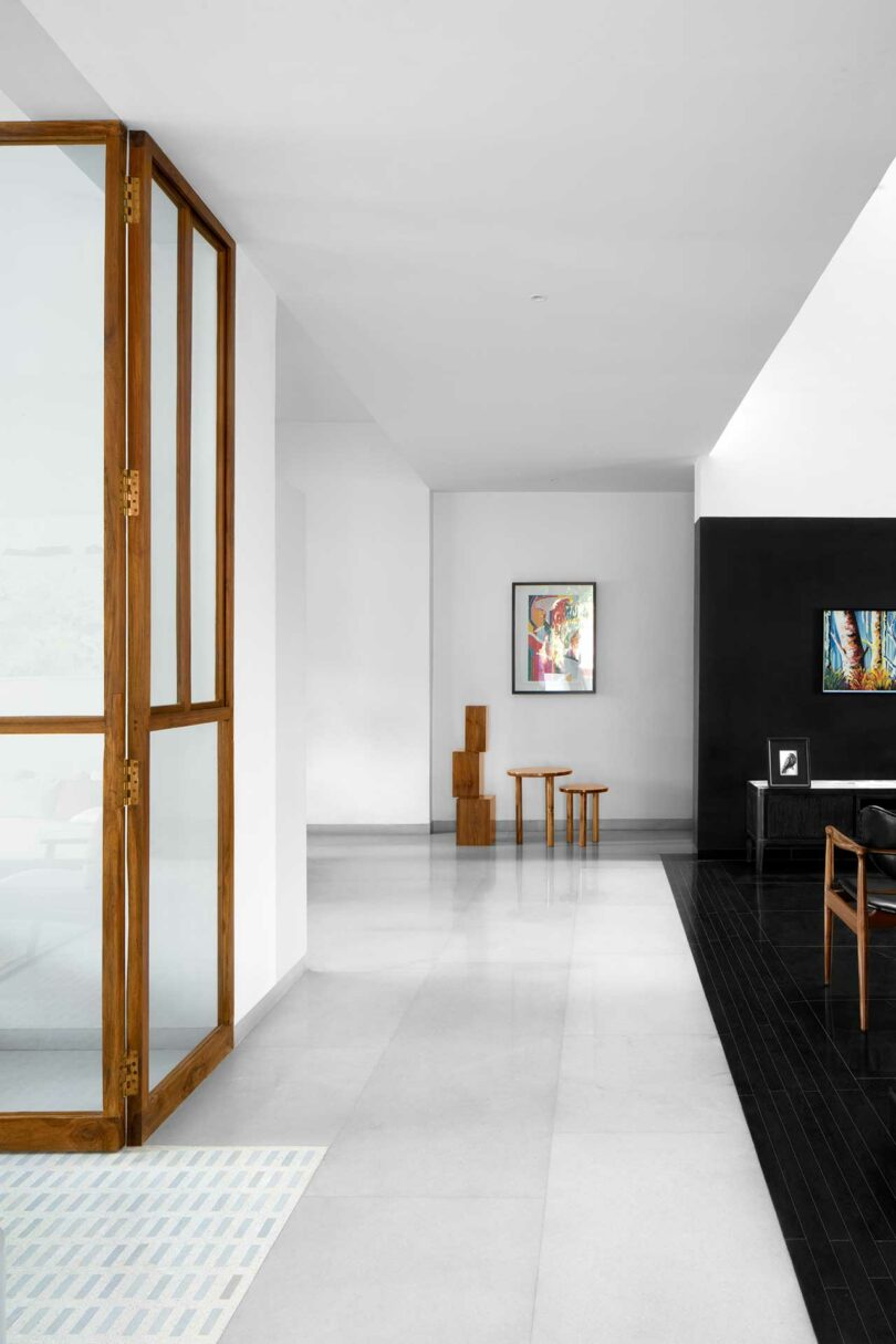 entrance hallway of modern house with white walls and and black room to right