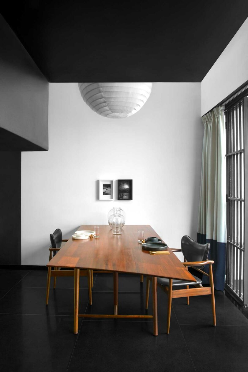 interior shot of modern dining room with simple wood table and chairs with white globe light above