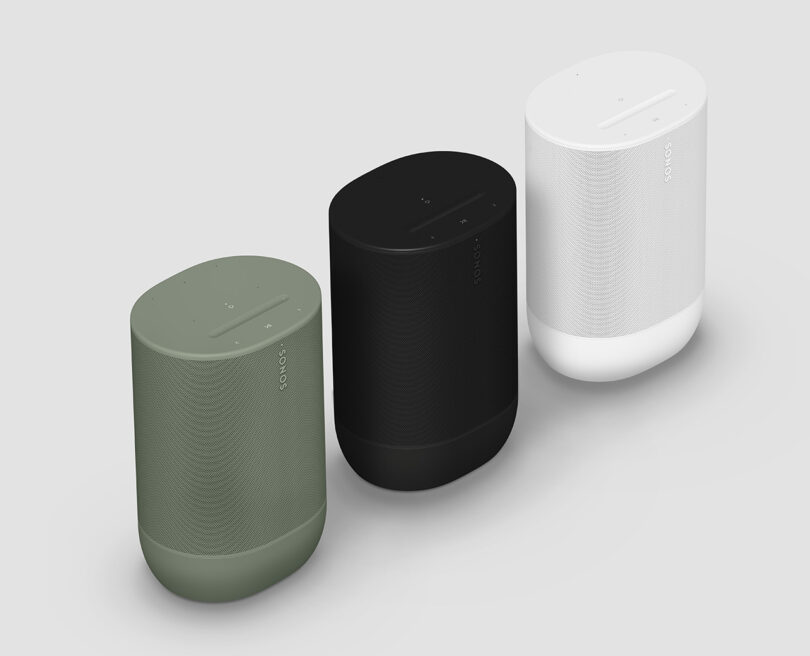 A trio of green, black, and white Sonos Move 2 wireless speakers lined up from a diagonal overhead perspective.