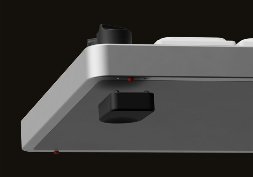 3D render of The Knob keyboard's underside with an add-on foot being installed onto the bottom to improve angled ergonomics.
