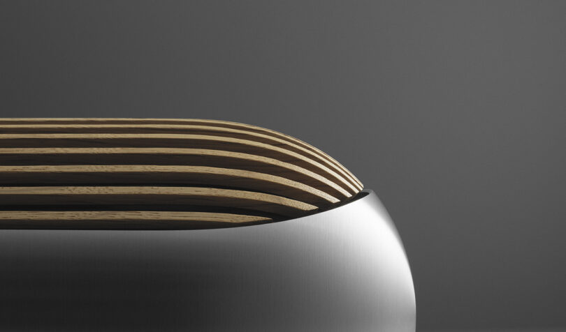 Side view of the pill-like shape of the slatted wood cover lower half of the Beolab 8 wireless speakers.