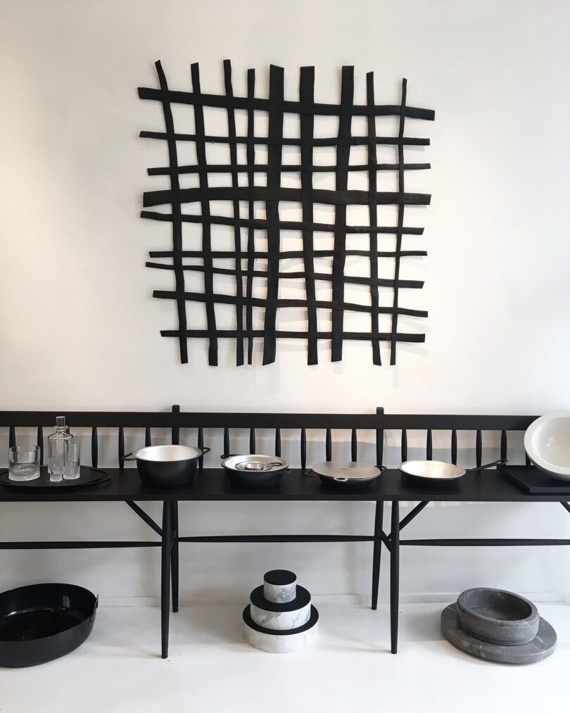 home furnishings store with black abstract art, a long black bench, and black and white tablewares