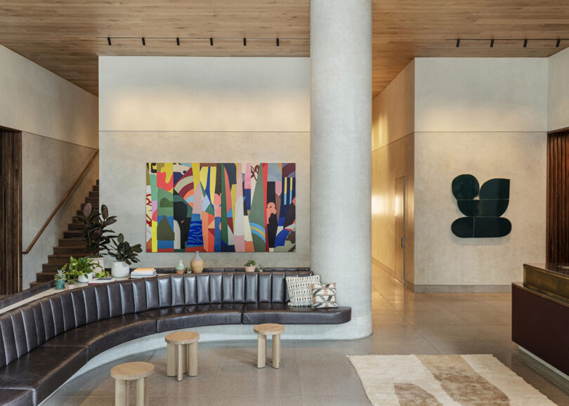 styled hotel lobby with curbed black leather sofa and abstract piece of art